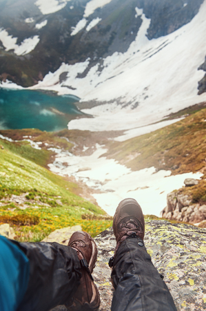 Legs of traveler sitting on top of mountain outdoor. Travel conceptの写真素材