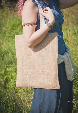 Woman holding empty linen bag outdoor. Template mock upの写真素材
