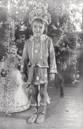 Vintage photo of little girl near fir tree. Christmas and New Year party