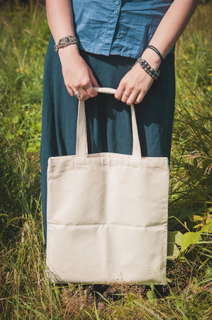 Woman holding empty linen bag outdoor. Template mock upの写真素材