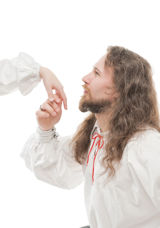 Handsome man in medieval shirt kissing hand of woman isolatedの写真素材