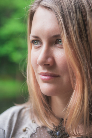 Portrait of beautiful thoughtful woman outdoor in summerの写真素材