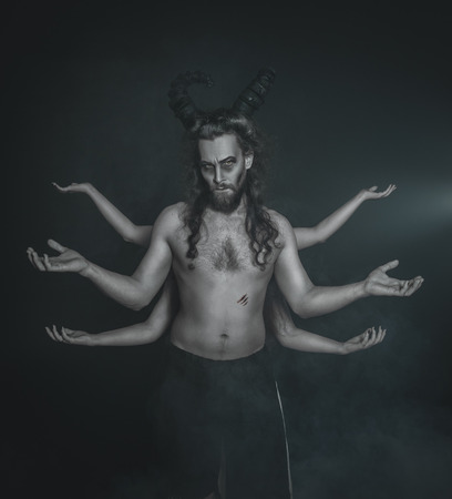 Terrible ghost with four hands on dark background