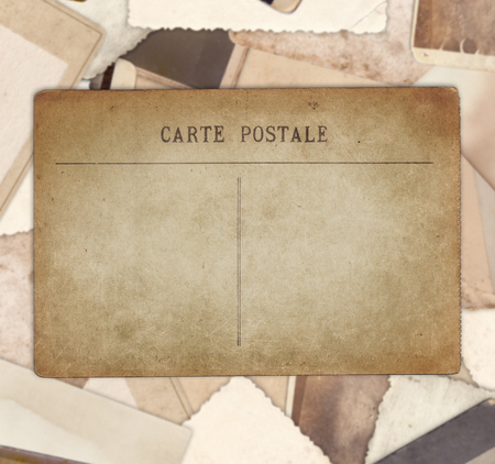 Vintage postcard on heap of old photos backgroundの写真素材
