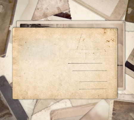 Vintage postcard on heap of old photos backgroundの写真素材