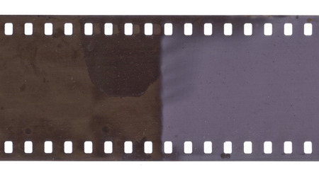 Strip of old film with dust and scratches isolated on whiteの写真素材