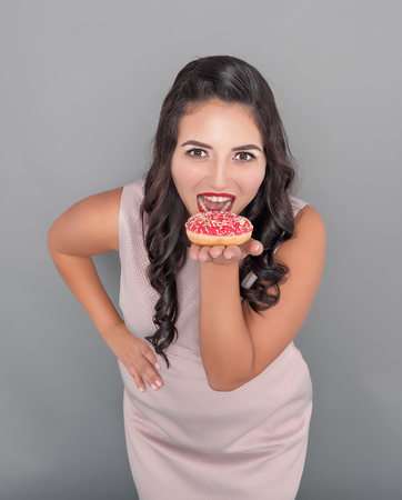 Beautiful happy plus size woman with donut. Body positive concept