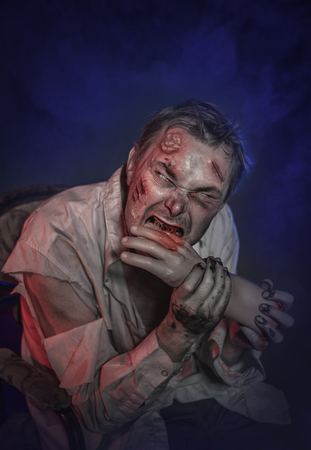 Horror terrible scary zombie man eating hand. Halloween sceneの写真素材