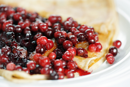 Thin delicious pancake with berries on white backgroundの写真素材