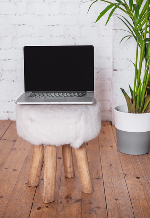 Mock up of laptop with blank black screen on the chairの写真素材