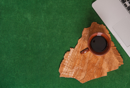 Cozy green workplace with laptop and cup of coffee. Mock up for designの写真素材