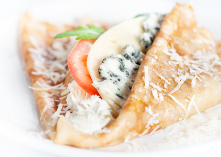 Thin delicious pancake with four types of cheese on white backgroundの写真素材