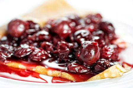 Thin delicious pancake with berry jam on white backgroundの写真素材