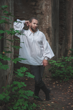 Handsome man in medieval costume standing outdoor