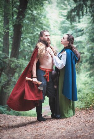 Handsome Warrior Viking man with beautiful medieval woman standing outdoorの写真素材