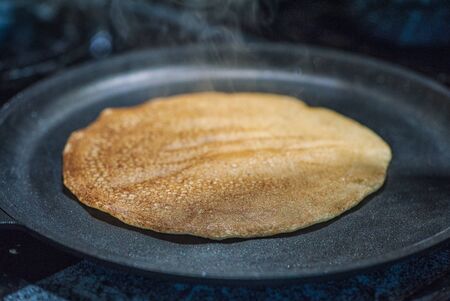 Making delicious pancake on iron frying panの写真素材