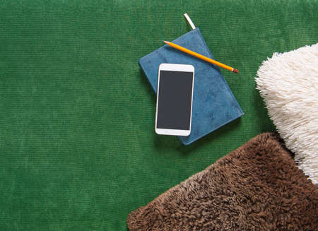 Top view with notebook, smartphone and pencil on fabric background. Mock up for designの写真素材