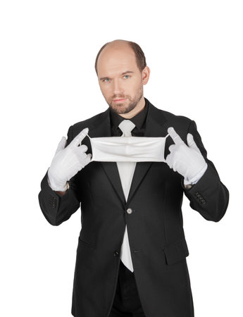 Handsome young business man with black gloves put surgical medical virus protection mask on his face isolated on whiteの写真素材