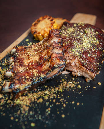 Spicy hot grilled caramelised pork ribs with corn on the cutting boardの写真素材