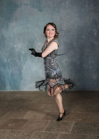 Beautiful happy woman in retro 20 - 30 style dancing in the room