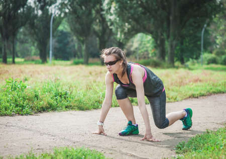 Active beautiful woman ready to run in the city park outdoor. healthy lifestyle