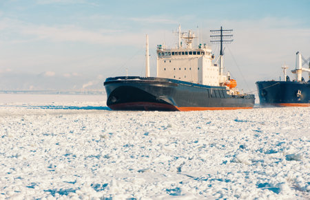 Winter shipping. Big cargo in ships frozen ice sea fairway