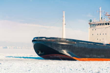 Winter shipping. Big cargo ship in frozen ice sea fairway