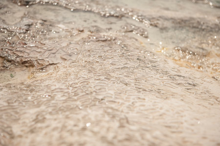 Natural background of porous travertine beige stone texture with water