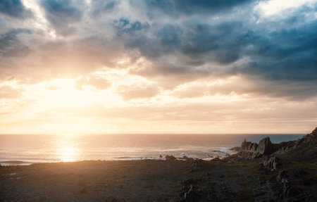 Dramatic scene with big rocks, sea, sunbeam and beautiful sundown