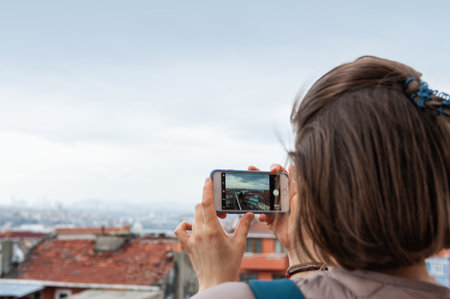 Traveler woman captures Istanbul's cityscape on a smartphone during a sightseeing adventure