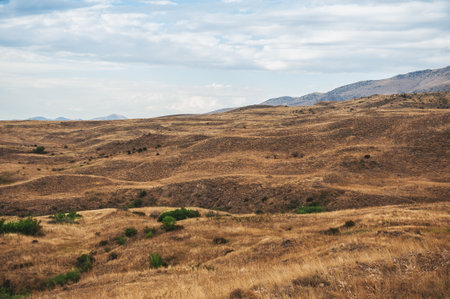 Majestic mountains under a blue sky filled with clouds, showcasing natural beauty and rugged terrain