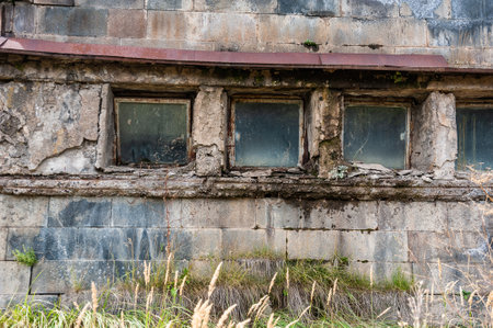 Cracked windows on an abandoned Soviet-era building with weathered concrete