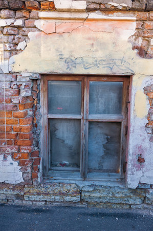 Old glass window on the weathered vintage brick cracked wallの写真素材