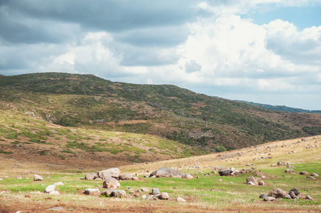 Dramatic mountain valley under a moody, cloudy sky with a rugged landscape