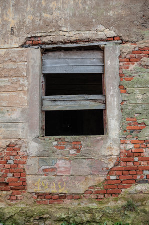 Old rustic boarded up window on the ancient abandoned red brick houseの写真素材