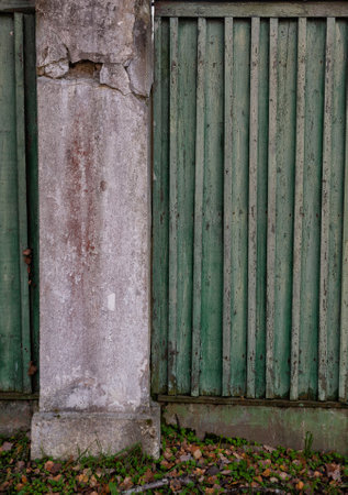 Weathered aged green wooden fence with rustic vertical slatsの写真素材