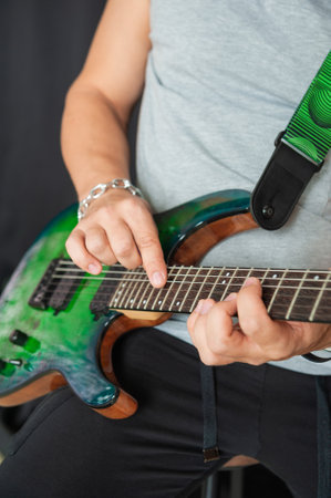 Close-up of musician hands skillfully playing electric guitar strings