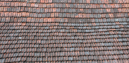 Close-up of a weathered clay roof, showcasing rustic textures and aged charm