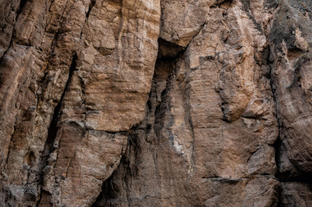 Weathered rock cliff texture background showcasing rugged texture and natural fissuresの写真素材