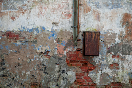 Weathered wall with peeling paint and rusted metal box reveals rustic grunge textureの写真素材