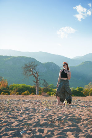 Stylish beautiful woman walking barefoot in nature captures serenity and adventureの写真素材