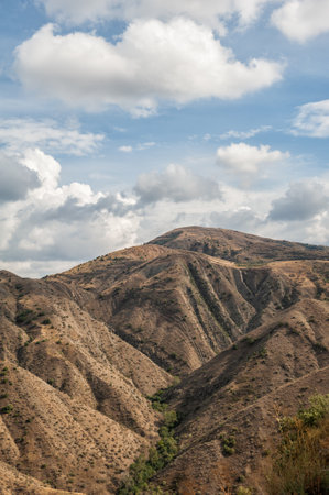 Majestic mountains of Armenia under a blue sky filled with clouds, showcasing natural beauty and rugged terrainの写真素材
