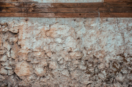 Historic wall made of rugged weathered stones. Detailed close-up of ancient stonework with rich,...