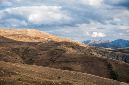 Majestic mountains under a blue sky filled with clouds, showcasing natural beauty and rugged terrain
