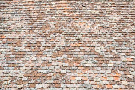 Close-up of an aged, weathered tile roof showing intricate textures and earthy tonesの写真素材