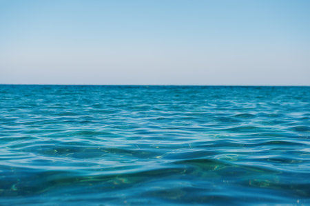 Sea water and blue sky in a calm day from low perspectiveの写真素材