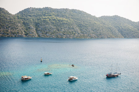 Arial view of the floating boats yacht in blue mediterranean sea and hills in Turkey