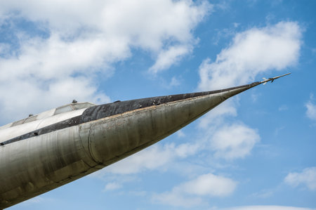 Old supersonic jet nose against a blue sky. Weathered metal fuselage highlights vintage aerospace design. Ideal for aviation and technology themesの写真素材