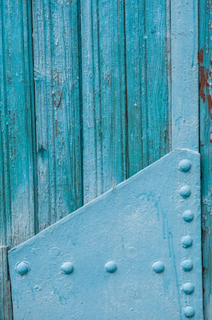 Weathered blue wooden planks with metal rivets. Rustic texture and chipped paint create a vintage industrial backgroundの写真素材
