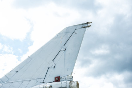 Aircraft vertical fin against cloudy overcast sky background. Detailed aviation mechanics showcase vintage aerospace designの写真素材